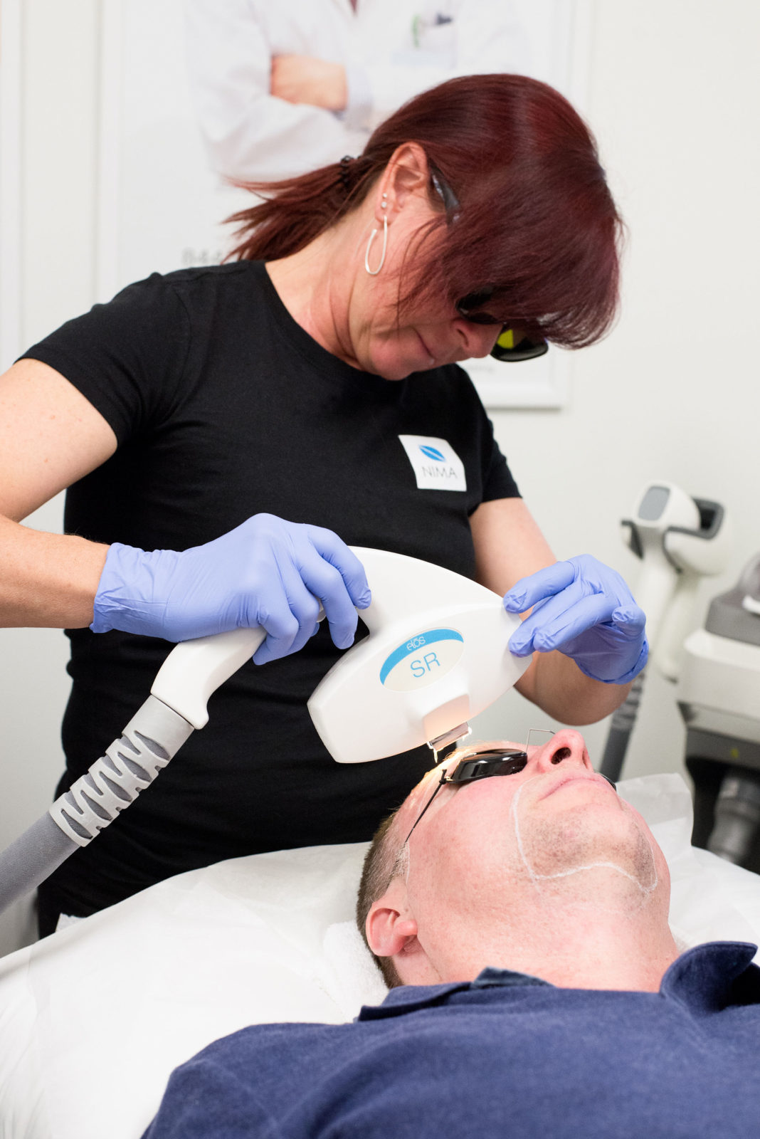Aesthetician performing facial laser service.