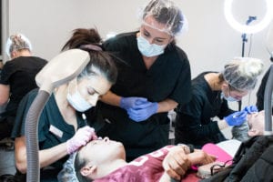 student performing microblading with teacher watching
