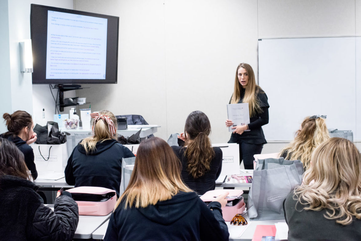 classroom of people learning about microblading